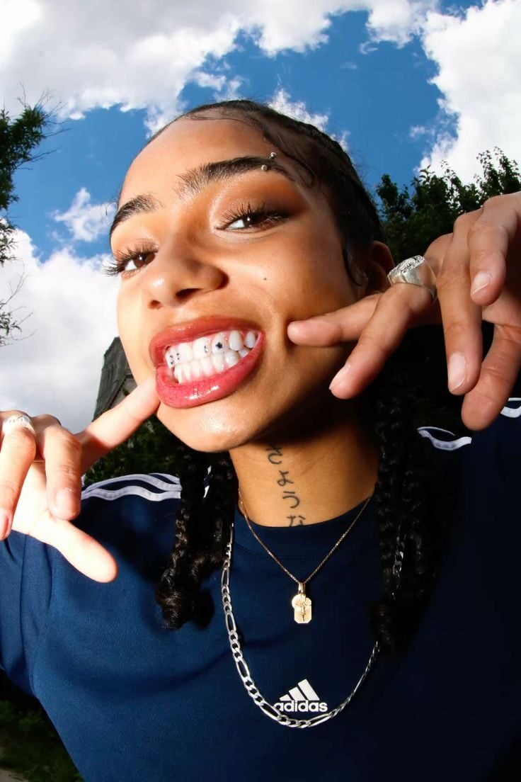 Jeune femme montrant pose de strass dentaires multicolores sur la dentition inférieure — Jux Studio Bordeaux